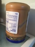 Natural peanut butter jar stored upside down in the refrigerator