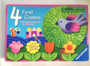 Four First Games box lid from Ravensburger with four flowers, a bird, a tree, a colored die, and one playing piece shown on the cover of the box