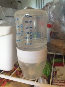 Avent baby bottle partially filled with water and placed upside down in freezer