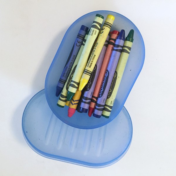 Blue translucent soap dish opened to show crayons stored inside