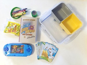 Clear plastic square container with removable colored nesting containers and toys for car ride