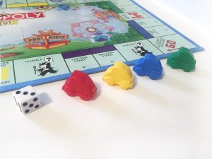 Red, yellow, blue, and green car game pieces to move around the Monopoly Junior board