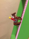 Lego minifiugure riding Lego plastic brick block horse on pink Mayka tape going up ladder