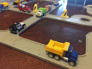 Driven pocket series dump truck blue yellow on interconnecting gray road pieces set up