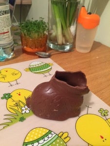 Chocolate bunny missing head on Easter themed place mat