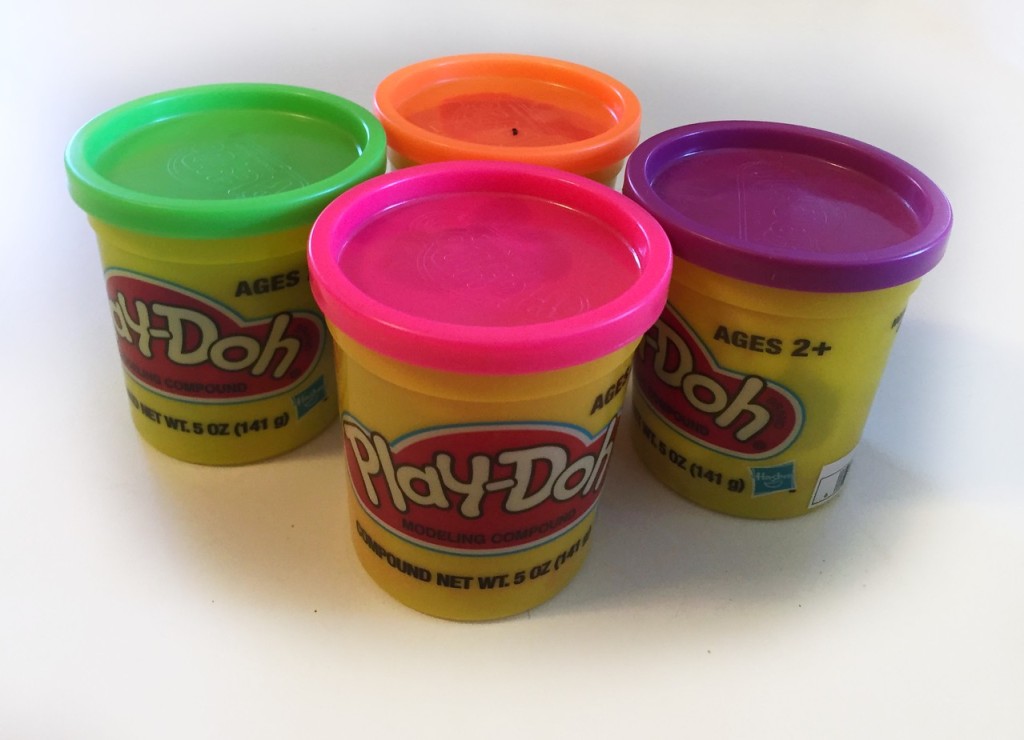 Containers of Play-Doh in pink, green, purple, and orange