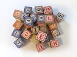 Uncle Goose wooden classic ABC blocks in Polish in pile on white surface