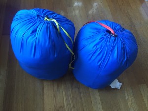 Kindercone and Nodder REI kids sleeping bags in blue side by side in stuff sacks