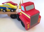 Melissa and Doug wooden car loader with red tractor trailer flatbed and four striped cars with numbers
