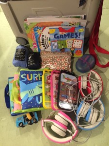 Close up of kid headphones, coloring kits, activity books, wooden cement mixer, crayon case, and electrical cords that fit into JetKids Bedbox