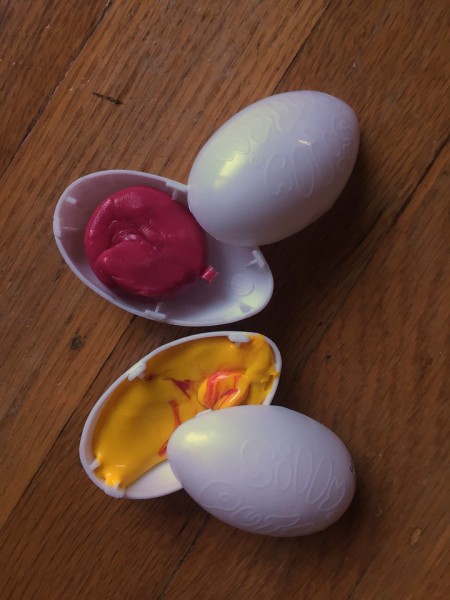 Scented silly putty eggs open showing pink and yellow (with pink streaks) putty inside