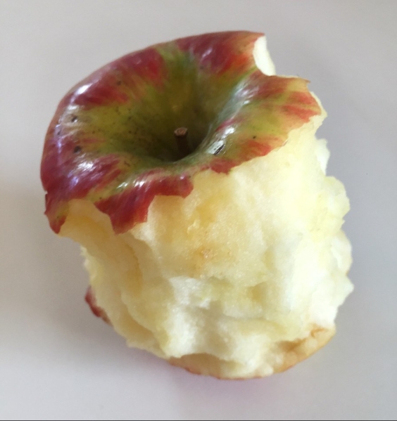 Half eaten red apple turning slightly brown