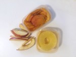 Leftover fruit apricot pineapple apple slices on counter in small containers