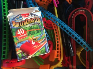 ThinkFun Roller Coaster Challenge logic puzzle game for kids card box on top of pile of track pieces