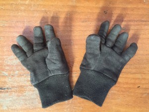 Kids brown gardening gloves covered with dirt