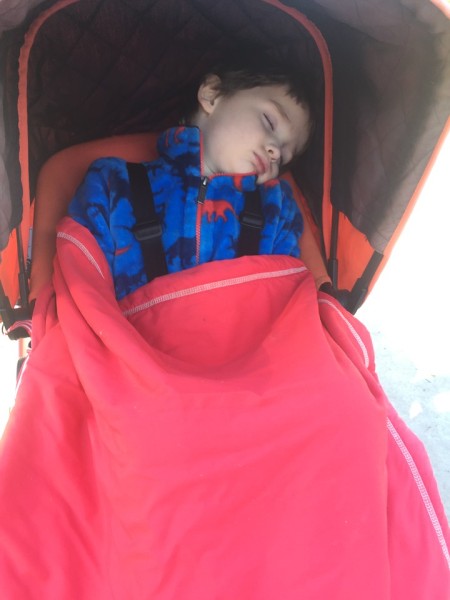 Child sleeping in Bugaboo Frog stroller with sunshade pulled down