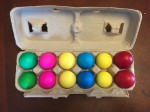 Easter eggs filled with confetti in egg carton arranged by color
