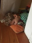 Four year old passed out on pillow on floor