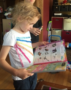 Child looking at Scratch and Sparkle Unicorns Activity book pages