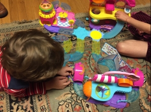 Kids playing with Zuru Hamsters in the House play sets combined into big city on floor rug