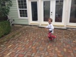 Child running in pajamas on brick patio outside french glass doors