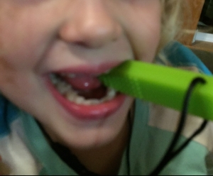Child chewing on sensory necklace green brick shaped Chew-E-Chainz
