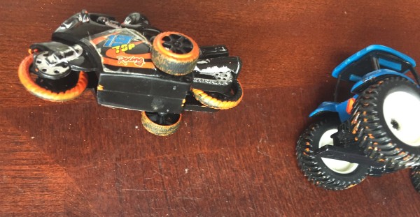 Motorcycle toy car and blue toy tractor with paint on wheels