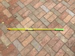Super water saber gun blaster tube yellow with green handle on brick patio background