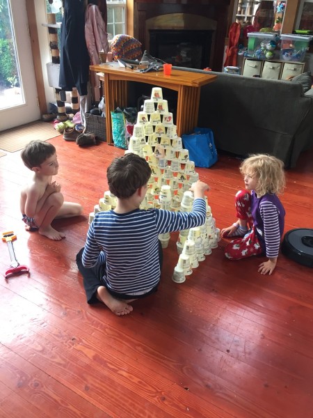 Kids using empty yogurt cups as building blocks toys