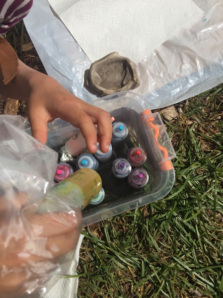 Child reaching into plastic container for colored dye in bottle from Tulip Tie-Dye Kit Party Box