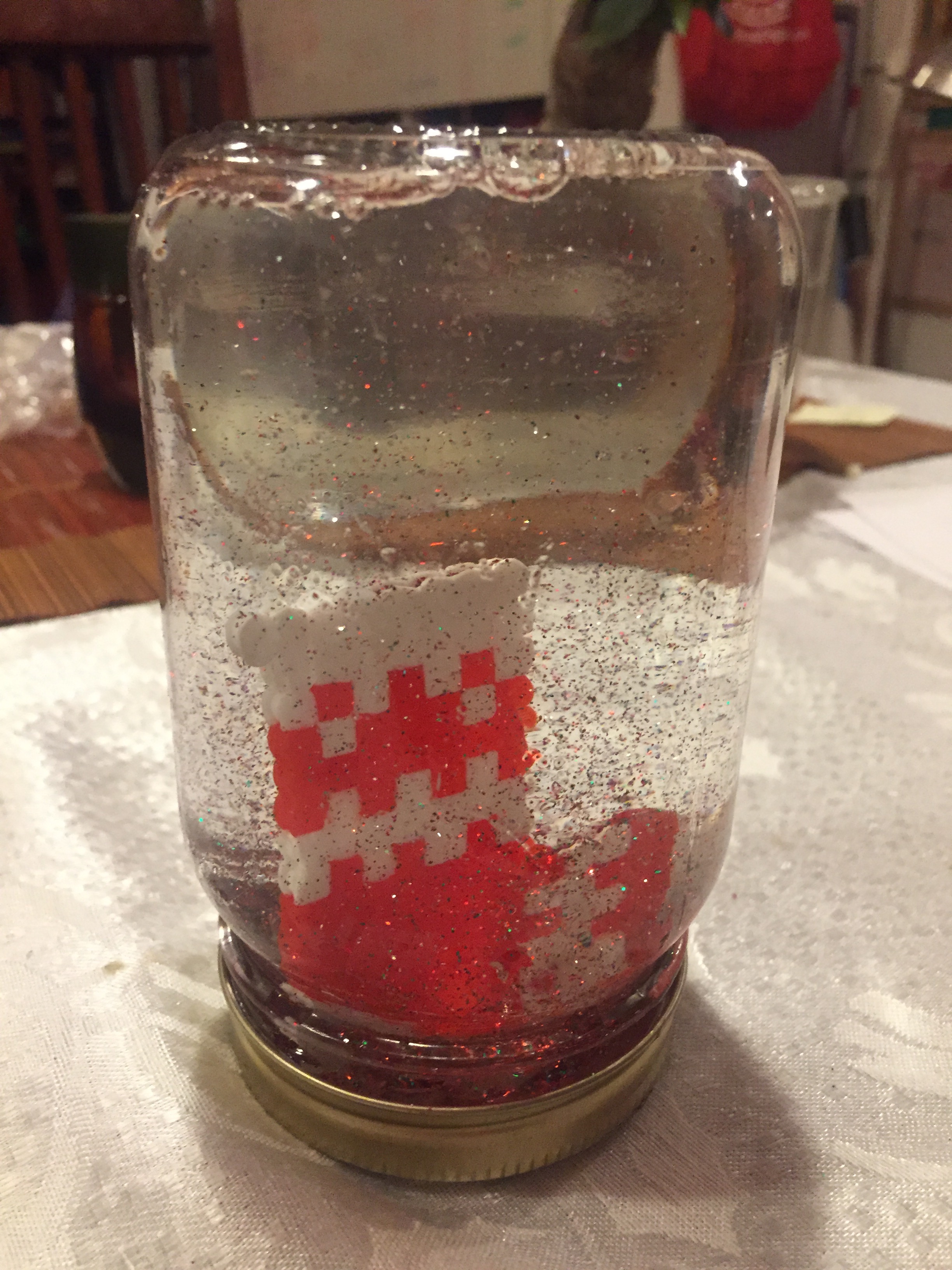 Homemade snow globe made by five year old kid with metly bead stocking and glitter