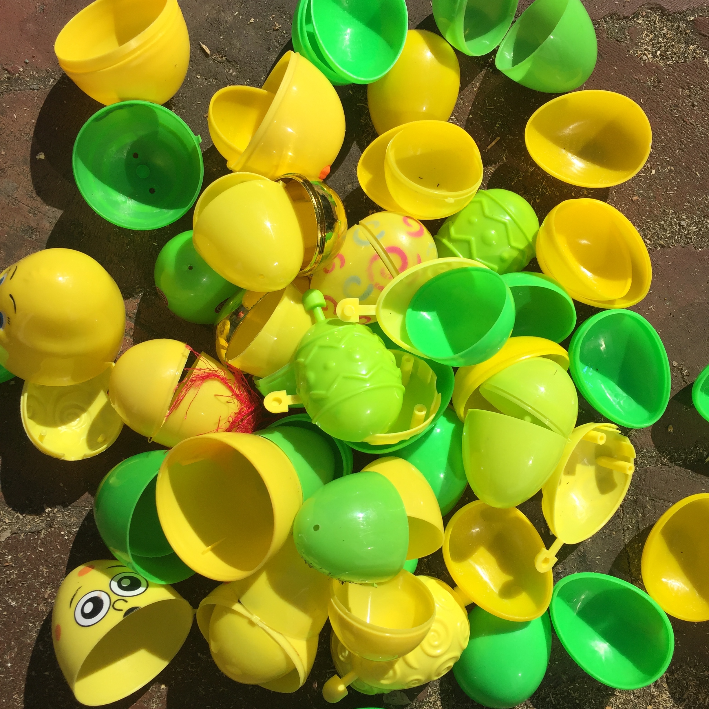 Green and yellow Easter eggs emptied on ground in pile