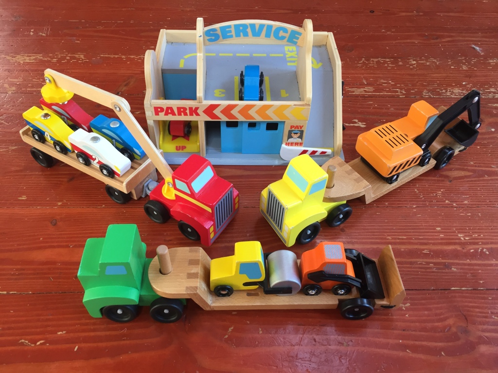 Melissa and Doug wooden service station garage car wash play set with cab and trailer with skid steer and steam roller and digger on flatbed trailer and race cars loaded on truck