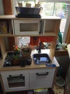 IKEA play kitchen with plants, tool. and water for kids' garden center