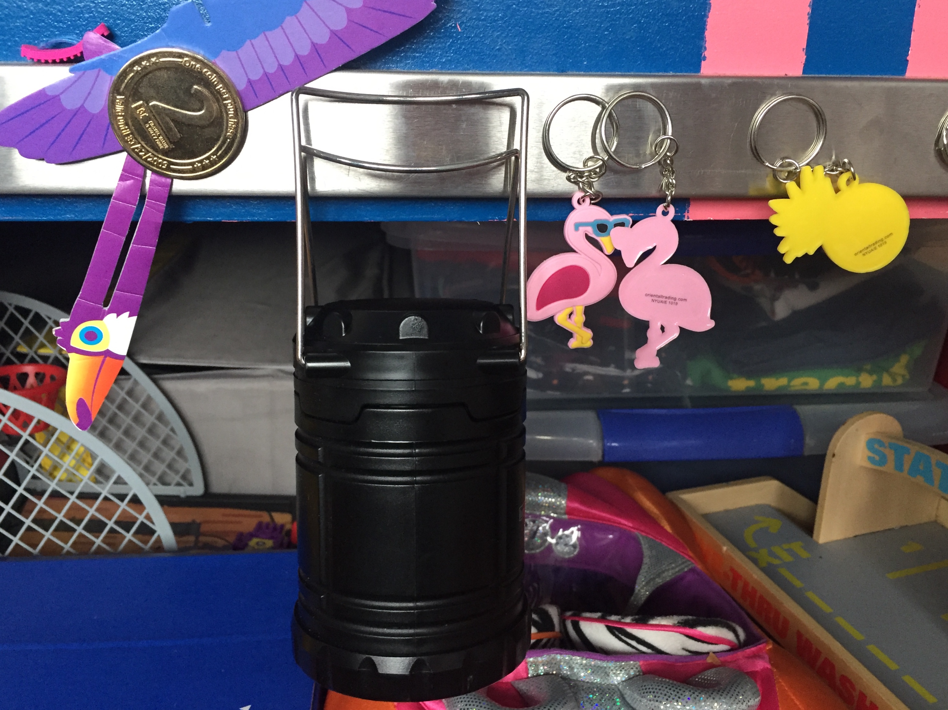 Magnetic knife rack attached to side of child's bed holding pretend coin money, lantern, key chains