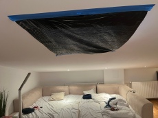 Black garbage trash bag taped to ceiling to block light from skylight