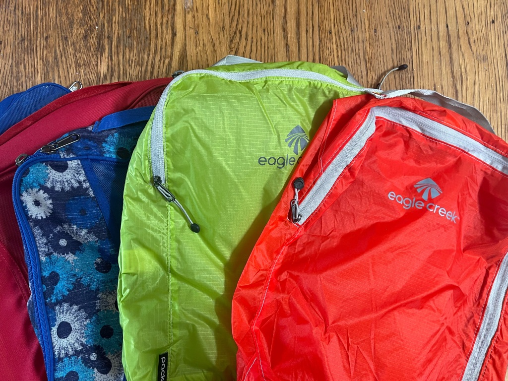Eagle Creek Pack-It Cubes in orange, green, blue floral print, and red colors and patterns