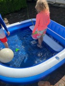 Family Splash pool with ten and eleven year old kids playing with inflatable balls