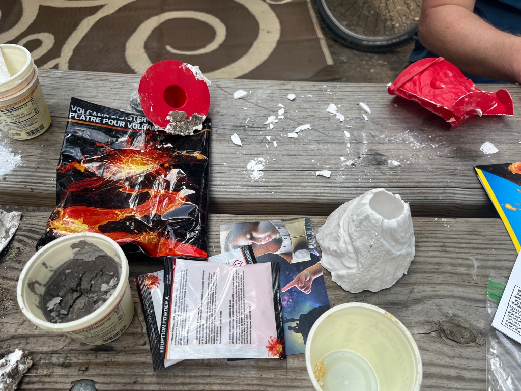 National Geographic Build Your Own Volcano Kit materials scattered about on picnic table