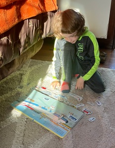 Seven year old playing with Usborne Airport Magnet Book