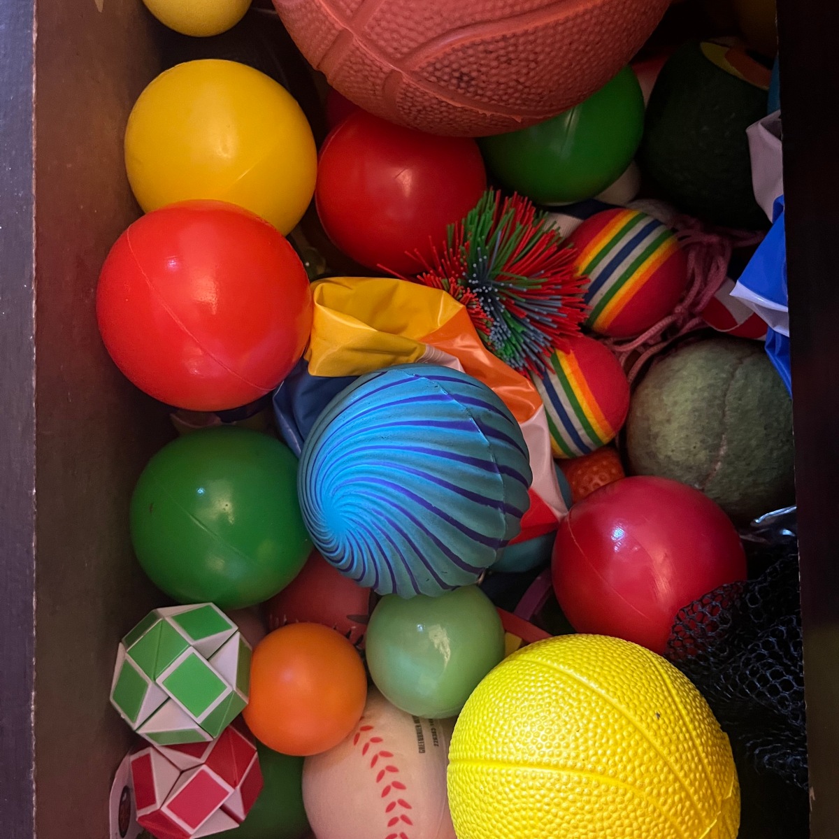 Spizzy blue ball inside drawer filled with other balls