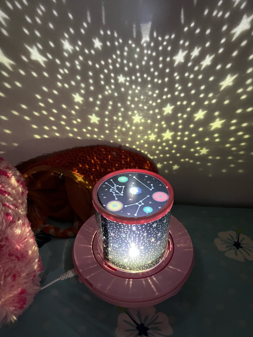 Star Night Light Projector for kids with constellations illuminating wall beside child's bed